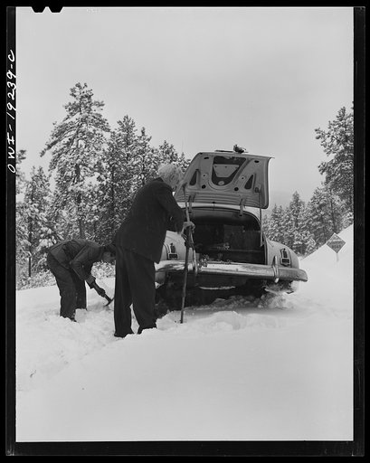 Untitled photo, possibly related to: Penasco, New Mexico. Doctor Onstine, seventy-seven year old country physician, putting chains on his car to get from Taos to the clinic operated by the Taos County cooperative health association
