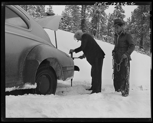 Penasco, New Mexico. Doctor Onstine, seventy-seven year old country physician, putting chains on his car to get from Taos to the clinic operated by the Taos County cooperative health association