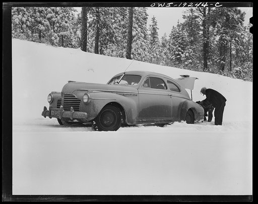 Untitled photo, possibly related to: Penasco, New Mexico. Doctor Onstine, seventy-seven year old country physician, putting chains on his car to get from Taos to the clinic operated by the Taos County cooperative health association