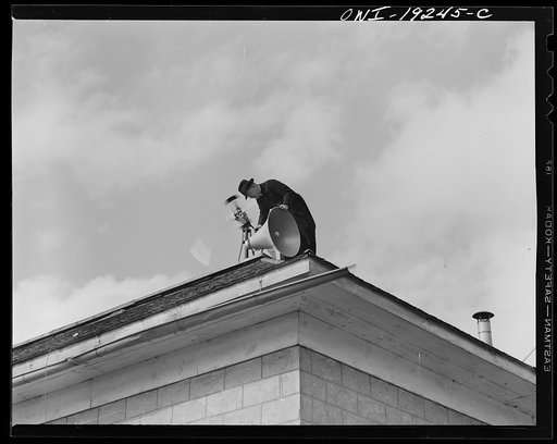 Untitled photo, possibly related to: Questa, New Mexico. Father Smith adjusting his loudspeakers on top of the Questa parish house, where he daily broadcasts to the people