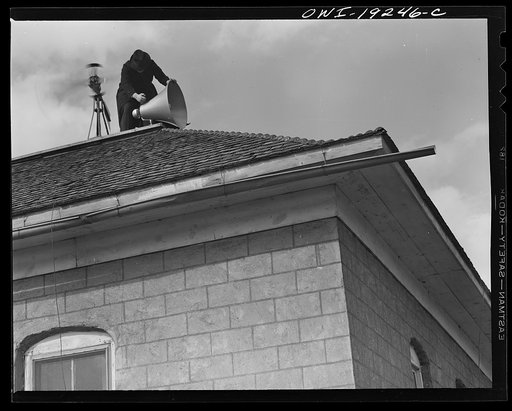 Untitled photo, possibly related to: Questa, New Mexico. Father Smith adjusting his loudspeakers on top of the Questa parish house, where he daily broadcasts to the people