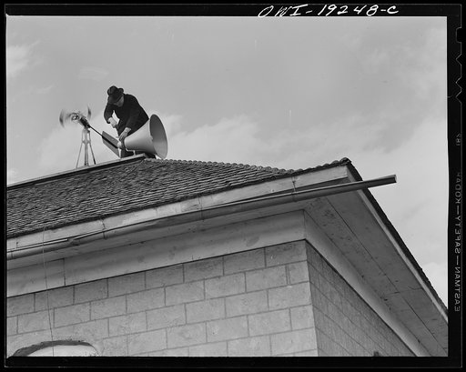 Untitled photo, possibly related to: Questa, New Mexico. Father Smith adjusting his loudspeakers on top of the Questa parish house, where he daily broadcasts to the people