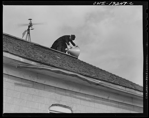Questa, New Mexico. Father Smith adjusting his loudspeakers on top of the Questsa parish house, where he daily broadcasts to the people