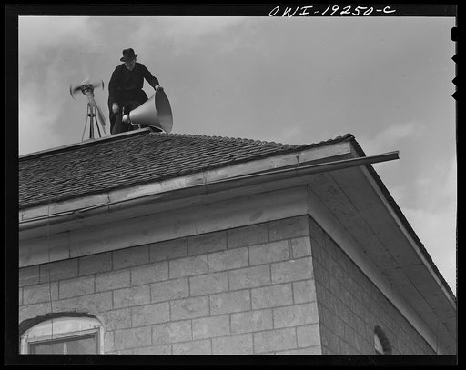 Untitled photo, possibly related to: Questa, New Mexico. Father Smith adjusting his loudspeakers on top of the Questa parish house, where he daily broadcasts to the people