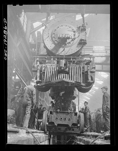 Topeka, Kansas. Wheeling an engine of the 3200 freight class in the Atchison, Topeka and Santa Fe Railroad locomotive shops. The engine is about to be lowered onto its wheels