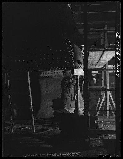 Topeka, Kansas. Welder at work on part of a fire box of a locomotive in the Atchison, Topeka and Santa Fe Railroad locomotive shops