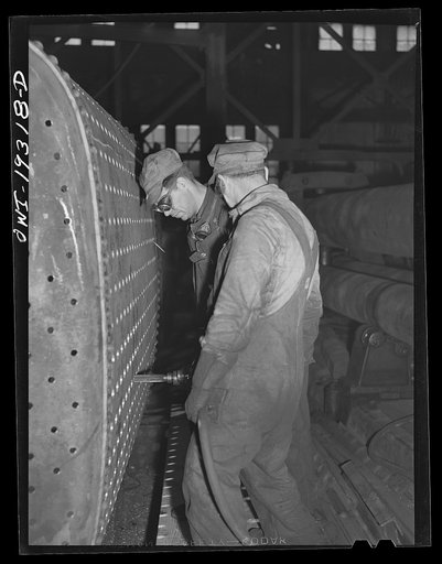 Untitled photo, possibly related to: Topeka, Kansas. Working on the fire box end of an engine in the Atchison, Topeka and Santa Fe Railroad locomotive shop