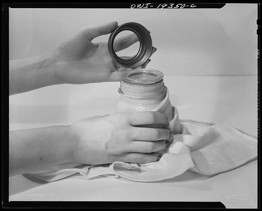 Steel-saving glass-top jars recommended by the War Production Board, Containers Division, for home canning of the Victory garden fruits and vegetables in 1943. Second step is to place the lid directly on top of the ring on the jar mouth, which must be smooth, even, and clean. To make a snug seal, li