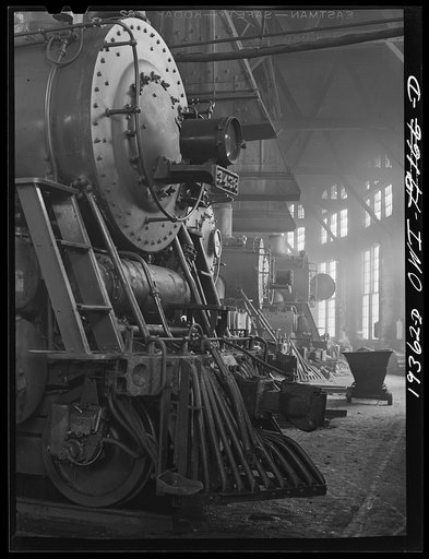 Untitled photo, possibly related to: Shopton, near Fort Madison, Iowa. Engines in the Atchison, Topeka and Santa Fe Railway roundhouse. Note train control mechanism on truck wheel of the engine in foreground