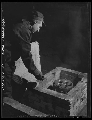 Shopton, near Fort Madison, Iowa. At the Atchison, Topeka and Santa Fe Railway diesel head shop, a diesel cylinder head being heated in a brick oven before welding cracks it