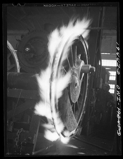 Shopton, near Fort Madison, Iowa. Retiring a locomotive driver wheel in the Atchison, Topeka and Santa Fe Railway locomotive shops. The tire is heated until it expands sufficiently to be slipped onto the wheel. Contraction on cooling will hold it firmly in place