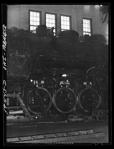 Untitled photo, possibly related to: Shopton, near Fort Madison, Iowa. Retiring a locomotive driver wheel in the Atchison, Topeka and Santa Fe Railway locomotive shops. The tire is heated until it expands sufficiently to be slipped onto the wheel. Contraction on cooling will hold it firmly in place