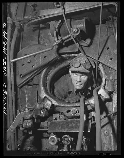 Topeka, Kansas. Homer Brandon, boilermaker's helper, crawling out of engine firebox door, in the Atchison, Topeka and Santa Fe Railway locomotive shops