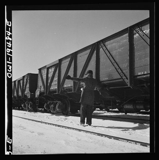 Joliet, Illinois. A conductor giving an engineer the signal to apply and release the brakes before the train leaves on the Atchison, Topeka, and Santa Fe Railroad between Chicago and Chillicothe, Illinois