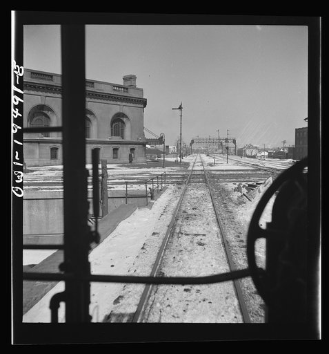 Joliet, Illinois. Passing the depot and tracks of the Rock Island and Alton Railroads along the Atchison, Topeka, and Santa Fe Railroad between Chicago and Chillicothe, Illinois