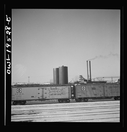 Untitled photo, possibly related to: Streator, Illinois. Going through the Atchison, Topeka and Santa Fe Railroad yard. In the background is a large bottling works