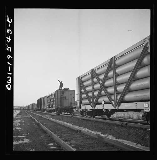 Untitled photo, possibly related to: Dahinda, Illinois. On the Atchison, Topeka and Santa Fe Railroad between Chillicothe, Illinois to Fort Madison, Iowa, a coupling pin jumps loose and the train breaks in two. The conductor, riding on top of the train, signals the engineer as they back up in order 