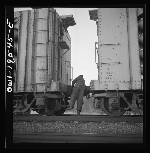 Dahinda, Illinois. A conductor on the Atchison, Topeka and Santa Fe Railroad between Chillicothe, Illinois and Fort Madison, Iowa coupling two cars that had been disconnected