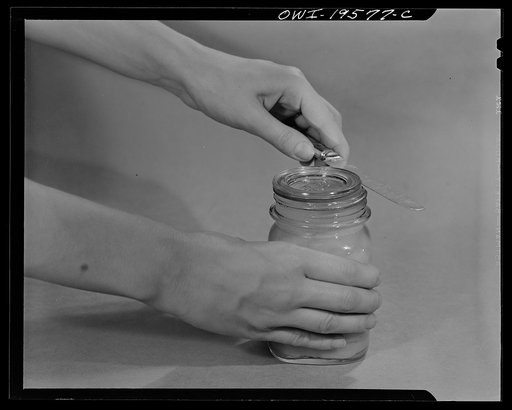 Steel-saving glass-top jars recommended by the War Production Board, Containers Division, for home canning of the Victory garden fruits and vegetables in 1943. To open the jar, insert knife between glass lid and rubber ring