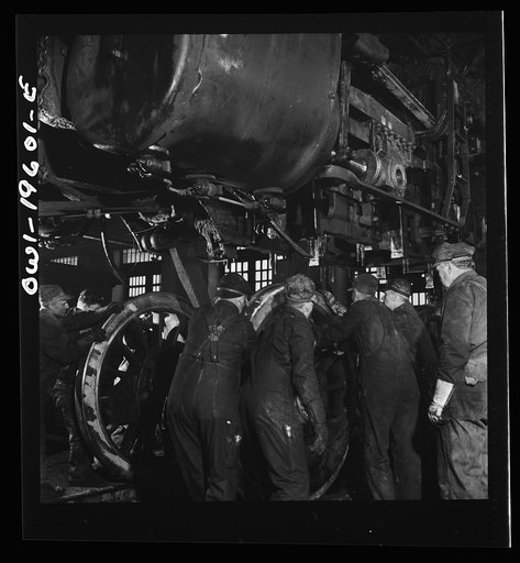 Untitled photo, possibly related to: Fort Madison, Iowa. Wheeling an engine in the Shopton locomotive shops of the Atchison, Topeka, and Santa Fe Railroad