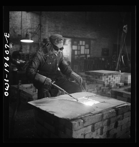 Fort Madison, Iowa. Welding cracks in the cylinder head of a diesel engine at the Shopton locomotive shops of the Atchison, Topeka, and Santa Fe Railroad