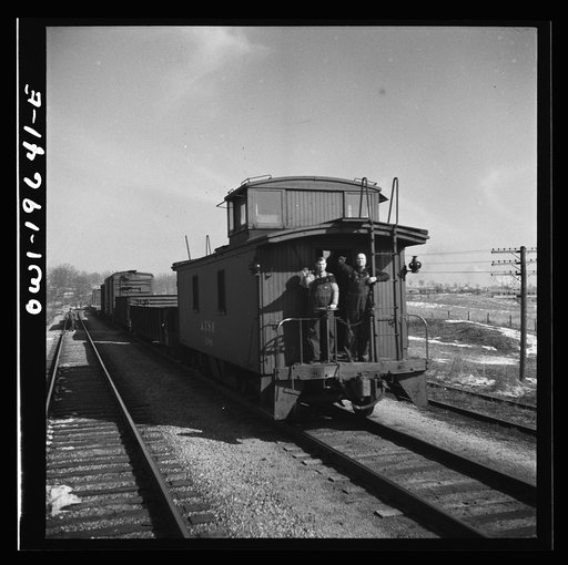 The crew of a passing east-bound freight train on the Atchison, Topeka, and Santa Fe Railroad between Fort Madison, Iowa and Marceline, Missouri giving the highball sign