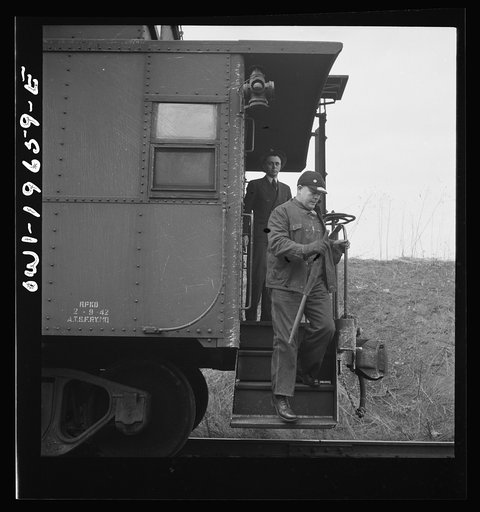 Untitled photo, possibly related to: On the Atchison, Topeka, and Santa Fe Railroad between Marceline, Missouri and Argentine, Kansas. Brakemen exchanging highball signs. When two trains pass one another, the brakeman watch the other train for signs of hot boxes or other damage. If all is well, the 