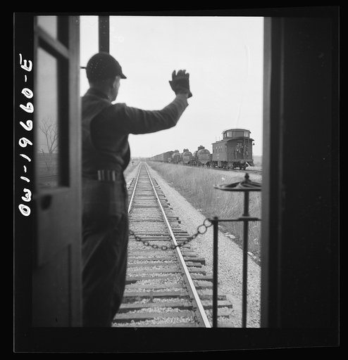 On the Atchison, Topeka, and Santa Fe Railroad between Marceline, Missouri and Argentine, Kansas. Brakemen exchanging highball signs. When two trains pass one another, the brakeman watch the other train for signs of hot boxes or other damage. If all is well, the highball sign is given. If not, other