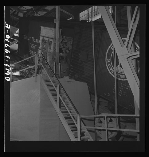 Argentine, Kansas. A car dumper at the Atchison, Topeka, and Santa Fe Railroad's ten-million bushel grain elevator. These cars of wheat are unloaded by tilting the car so that wheat can run out of the door in the center