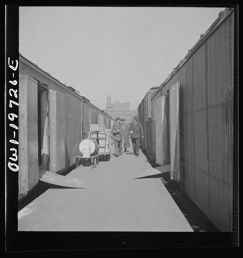 Untitled photo, possibly related to: Kansas City, Missouri. Loading and unloading cars at the Atchison, Topeka, and Santa Fe freight depot