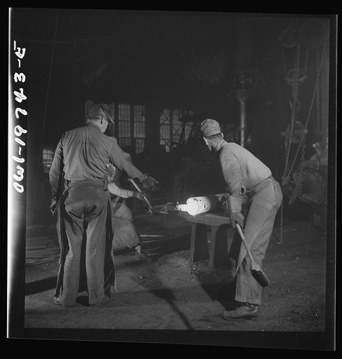 Untitled photo, possibly related to: Topeka, Kansas. In the blacksmith shop of the Atchison, Topeka, and Santa Fe Railroad. In addition to the making of the railroad equipment, the blacksmith shop is used for making important repairs to the shop machinery. Here a piston is being hammered out for a d