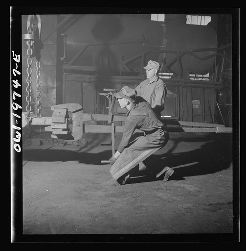 Topeka, Kansas. Workmen manipulating a hot forging which is being hammered under a steam hammer in the blacksmith shop of the Atchison, Topeka and Santa Fe Railroad