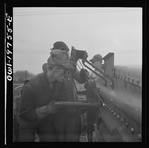 Untitled photo, possibly related to: Topeka, Kansas. Bucking rivets on a freight car which is being rebuilt in the shops of the Atchison, Topeka and Santa Fe Railroad
