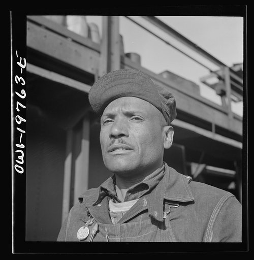 Untitled photo, possibly related to: Topeka, Kansas. Manny Hughes, steel car repairer's helper and rivet heater, at the car shops of the Atchison, Topeka and Santa Fe Railroad