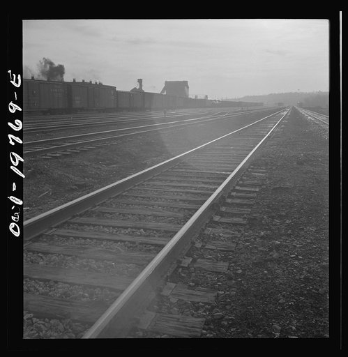 Untitled photo, possibly related to: Argentine, Kansas. An Atchison, Topeka, and Santa Fe train pulling out of the railroad yard. The operator at Turner tower acknowledges receipt of the conductor's message, between Argentine and Emporia, Kansas