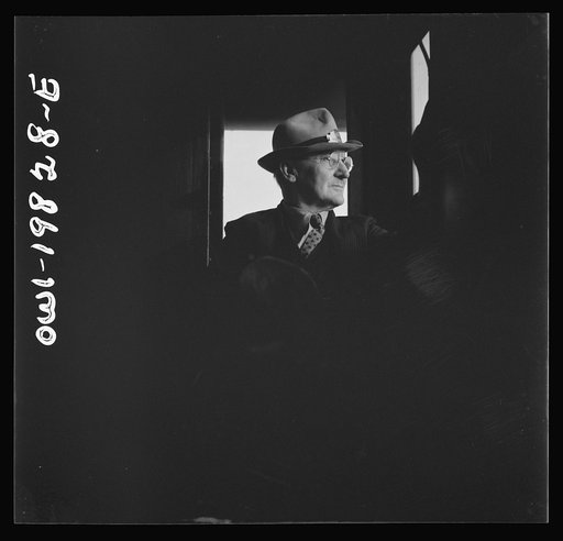Conductor W. E. Zink, watching the train from his window in the cupola of the caboose on the Atchison, Topeka, and Santa Fe Railroad between Emporia and Wellington, Kansas