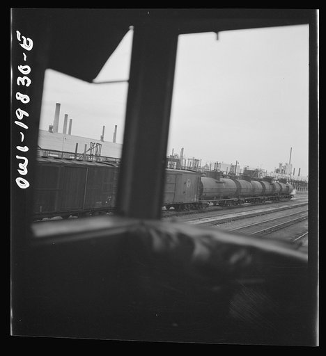 Untitled photo, possibly related to: Wellington, Kansas. An oil refinery seen through the windows of the cupola of the caboose on the Atchison, Topeka, and Santa Fe Railroad between Emporia and Wellington, Kansas
