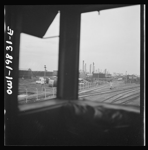 Wellington, Kansas. An oil refinery seen through the windows of the cupola of the caboose on the Atchison, Topeka, and Santa Fe Railroad between Emporia and Wellington, Kansas