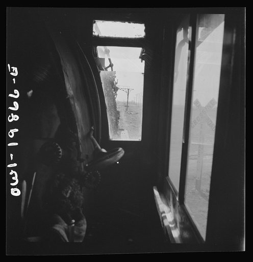 Kiowa, Kansas. The engineer's window in the cab of a locomotive. Waiting for block signal to change on the Atchison, Topeka, and Santa Fe Railroad between Wellington, Kansas and Waynoka, Oklahoma