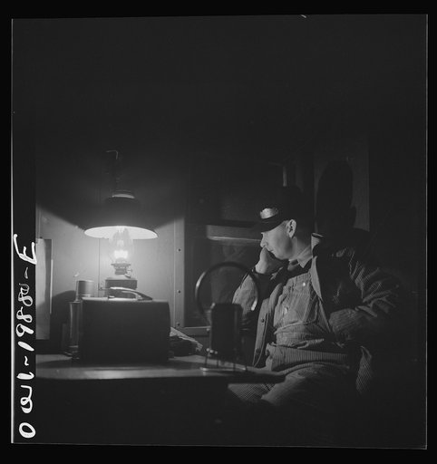 Untitled photo, possibly related to: Waynoka, Oklahoma. Brakeman Jack Torbet, sitting at the window of the caboose pulling out of Waynoka, Oklahoma on the Atchison, Topeka, and Santa Fe Railroad