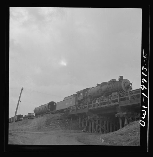 Wellington, Kansas. Train about to leave for the West coast from the Atchison, Topeka and Santa Fe Railroad yards, carrying a huge naval gun and giant metal cylinder for the Kaiser steel mill in California