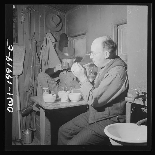 Conductor James M. Johnson and brakeman Jack Torbet of Waynoka, Oklahoma having lunch in the caboose on the Atchison, Topeka and Santa Fe Railroad between Waynoka, Oklahoma and Canadian, Texas