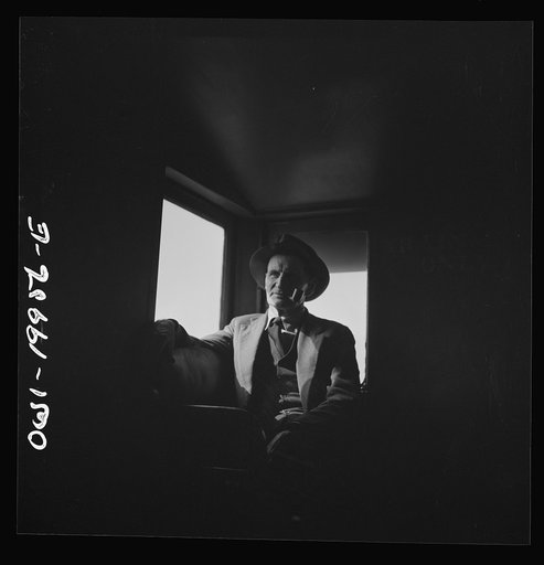 Untitled photo, possibly related to: Conductor J.R. Crawford, watching the train from his window in the cupola of the caboose along the Atchison, Topeka, and Santa Fe Railroad between Canadian and Amarillo, Texas