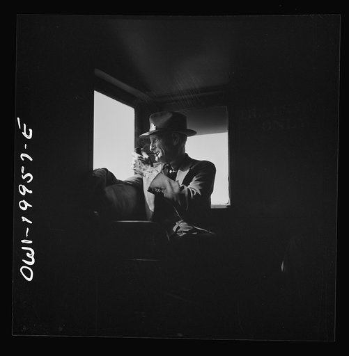 Conductor J.R. Crawford, watching the train from his window in the cupola of the caboose along the Atchison, Topeka, and Santa Fe Railroad between Canadian and Amarillo, Texas