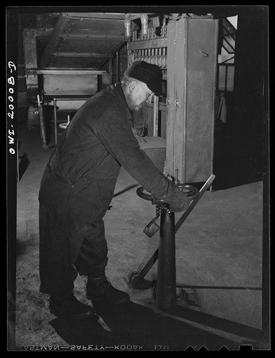 Untitled photo, possibly related to: Milwaukee Western Fuel Company, Milwaukee, Wisconsin. Workman in the processing plant of the Milwaukee Western Fuel Company shutting a valve to stop the flow of coal in one of the hoppers below