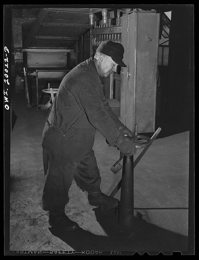 Milwaukee Western Fuel Company, Milwaukee, Wisconsin. Workman in the processing plant of the Milwaukee Western Fuel Company shutting a valve to stop the flow of coal in one of the hoppers below