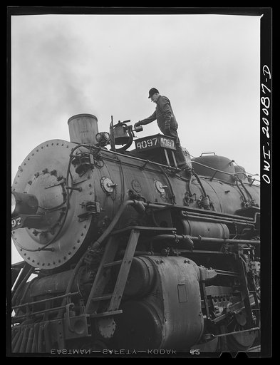 Wellington, Kansas. Engineer B.F. Hale, of the Atchison, Topeka and Santa Fe Railroad, oiling the bell of his locomotive before pulling out of Wellington yard
