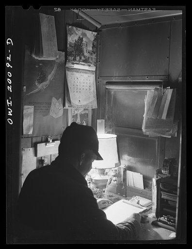 Conductor working on his records in the caboose enroute to Canadian, Texas