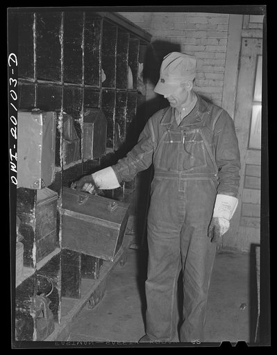 Wellington, Kansas. Atchinson, Topeka and Santa Fe engineer going off to work stops in the locker room for his tool kit