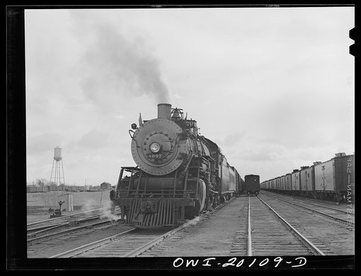Untitled photo, possibly related to: Wellington, Kansas. Engineer B.F. Hale, of the Atchison, Topeka and Santa Fe Railroad, oiling the bell of his locomotive before pulling out of Wellington yard